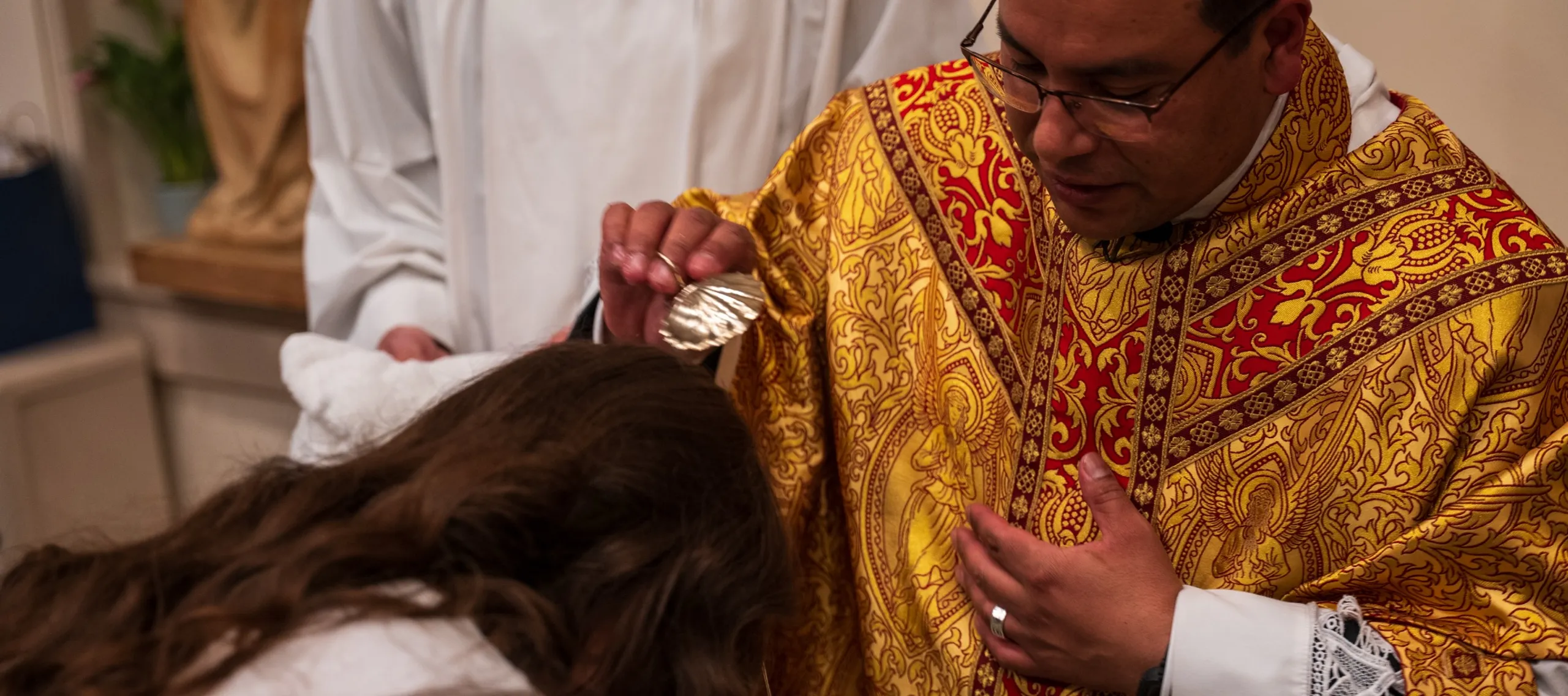 an adult being baptized at the font