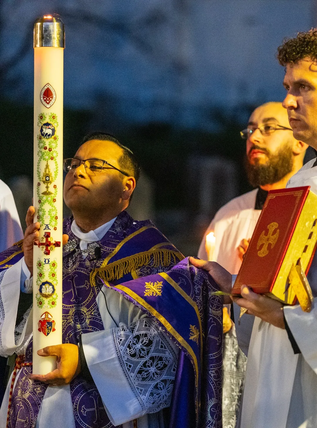 clergy carrying the paschal candle at the Easter Vigil